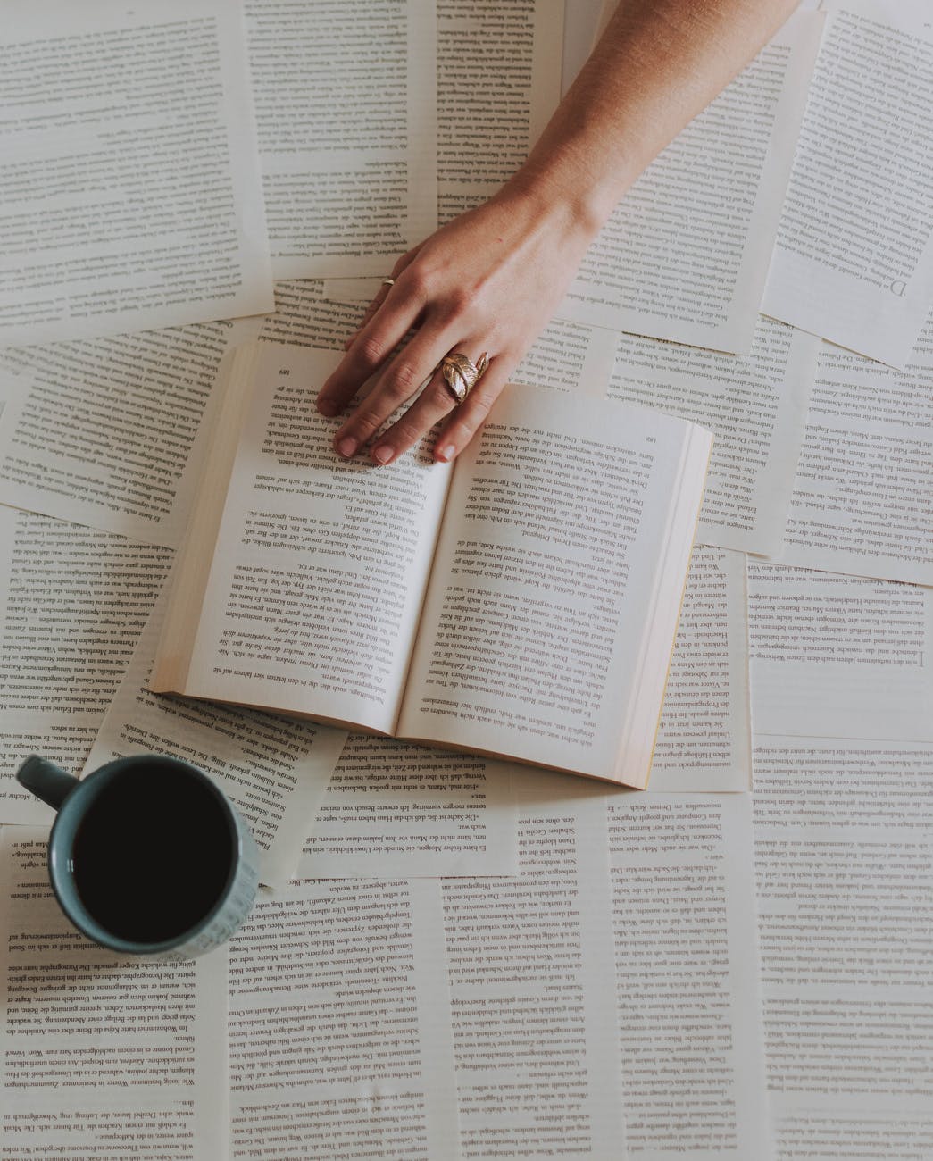 flat lay photography of an open book beside coffee mug